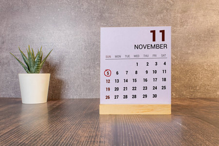 Wooden calendar on dark background, date 5 November.の写真素材