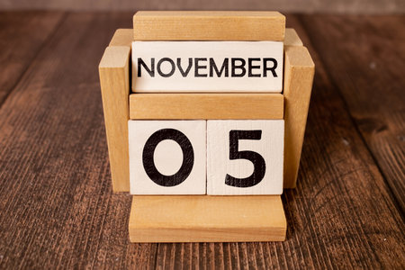 Wooden calendar on dark background, date 5 November.の写真素材