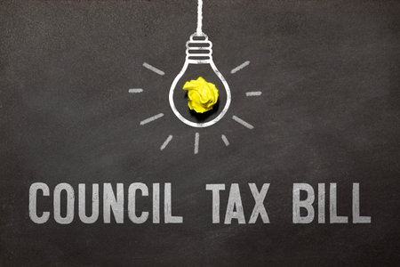 coUNCIL TAX BILL is written in a white notepad near a clipboard, calculator, green plant, glasses and a pen on a yellow and concrete backgroundd.の写真素材