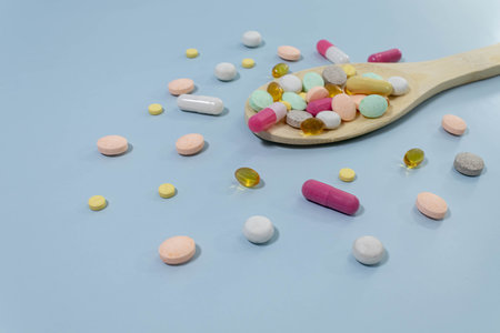 pills scattered on the table with a wooden spoon. High quality photoの写真素材