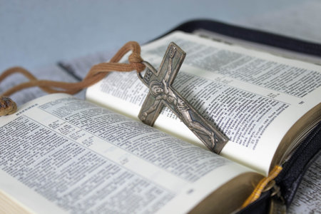 Closeup image of metal cross which places on open bible book, soft focus, concept for religious lifestyle of Christian people around the world.の写真素材