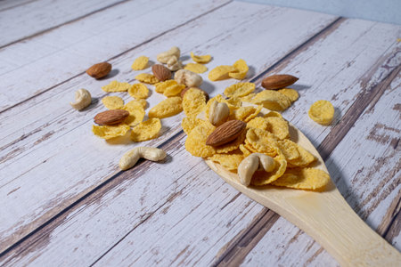 Beakfast cereals in wooden spoon. Healthy muesli with oat flakes, nuts and raisins isolated on white backgroundの写真素材