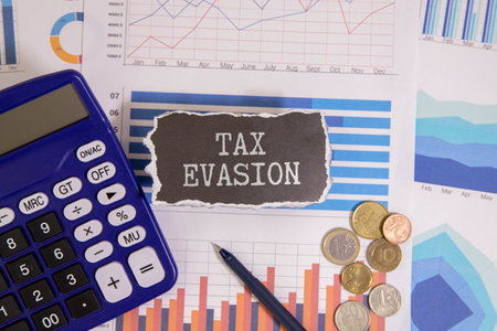 Notepad with text tax evasion on the business charts and pen,businessの写真素材