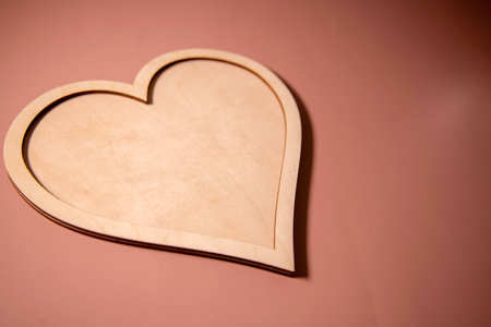 Wooden heart placed on a brown wood board.の写真素材