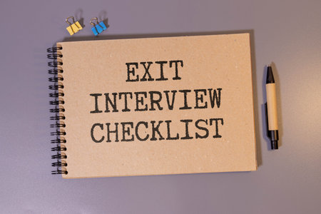 Handwritten Exit Interview Checklist Message On Notebook With Blue Marker And Spectacles Over Office Deskの写真素材