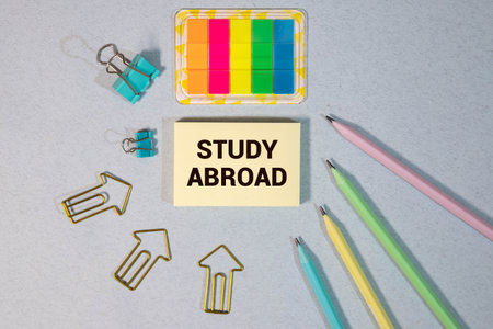 Study Abroad Wooden blocks with STUDY ABROAD text of concept, a pen, and plane toys.の写真素材