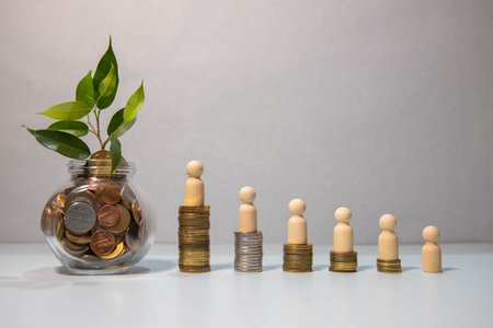 Small house on the coin ladder Seedlings planted on coins in glass bottles. The concept of saving money to buy a house. Investment property business growth Save money to become a dream homeowner.の写真素材