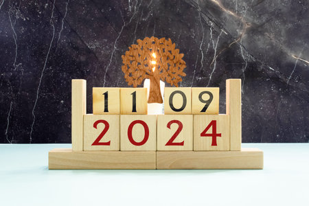 Wooden calendar with the date September 11 and gypsophila flowers on a gray concrete background