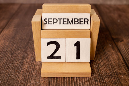 Wooden calendar with the date September 21 and gypsophila flowers on a gray concrete backgroundの写真素材