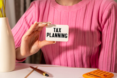desk clock and notepad on the work desk. text TAX PLANNING.の写真素材