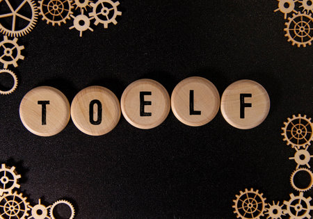 wooden blocks spelling out TOEFL symbolize education constraintsの写真素材