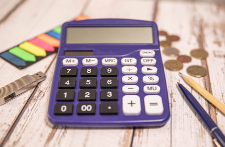 Purple digital calculator on a wooden background. Top view with place to insert text