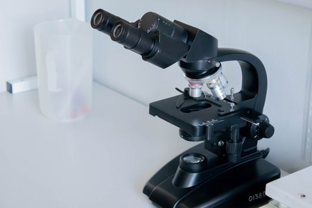 Old black microscope isolated on white background.