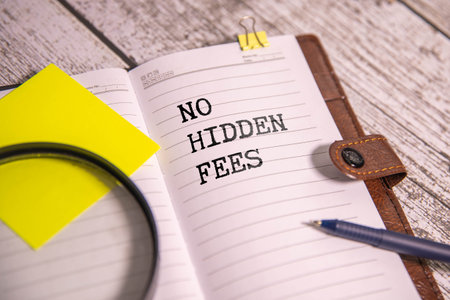 A notebook with the inscription NO HIDDEN FEES. With a decorative grocery cart along with small packaged mailboxes in the background. Lettering content matters for business, sales, and marketing.の写真素材
