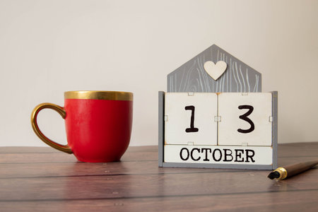 White block calendar present date 13 and month October on wood background