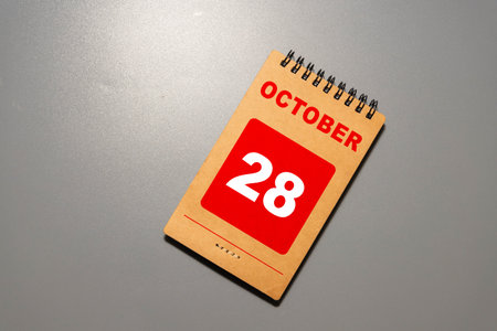 October 28. Day 28 of month. Calendar cube on wooden background with red apples. Autumn season.