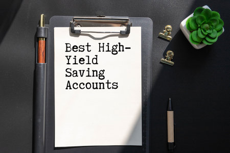 Business and finance. On the blue financial charts is a piece of cardboard that says - Best High-Yield Saving Accounts.の写真素材