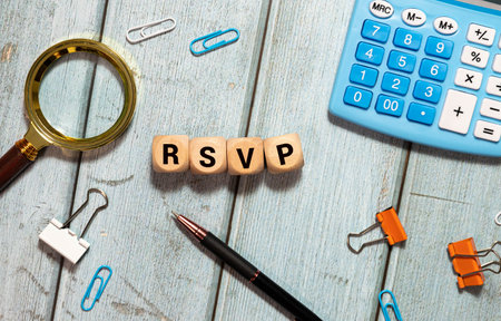 rsvp acronym request for a response from the invited person on wooden cubes with female hand.の写真素材