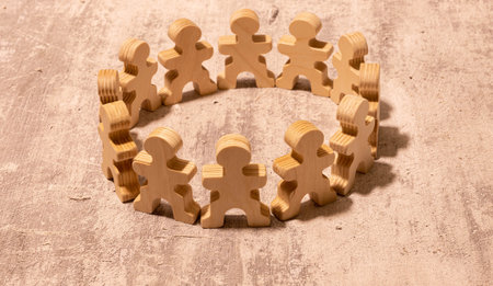 Wooden blocks arranged in a circle. Circle of wooden blocks representing unity of diverse elements. Wooden blocks placed in a circle on a neutral white background, with natural shadows.の写真素材