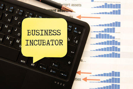 Motivational words: BUSINESS INCUBATOR. Man holds a piece of paper with the text: BUSINESS INCUBATOR. Business and finance conceptの写真素材