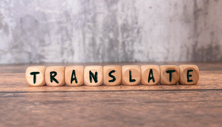 Woman making word Translate with wooden cubes at white table, top viewの写真素材
