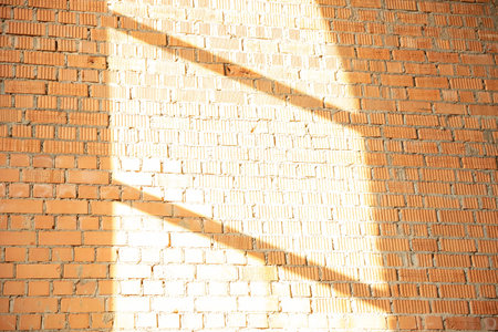 Brick wall with shadow and rays of light from the windowの写真素材