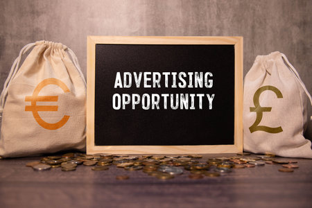 Business and Now Hiring concept. Copy space. Words on wooden blocks with a yellow-orange backgroundの写真素材