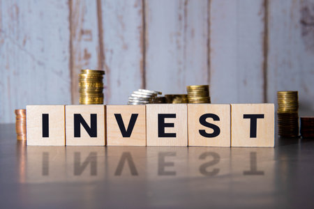 Best investment symbol. Turned wooden cubes and changed and changes the word 'invest' to 'best'. Beautiful orange background. Business and best investment concept. Copy space.の写真素材