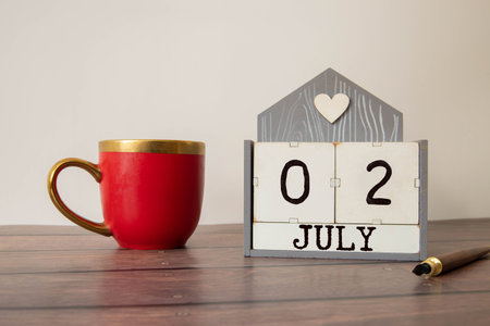 Close up of a wooden perpetual calendar showing the 2nd of July. Shot close up isolated on a white background.の写真素材