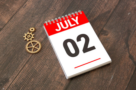 Close up of a wooden perpetual calendar showing the 2nd of July. Shot close up isolated on a white background.の写真素材