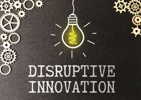 Concept of disruptive innovation and agile business methodology. Phrase, text DISRUPTIVE INNOVATION on the glass of a magnifying glass on a gray background.の写真素材