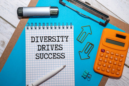 A colored block with text DIVERSITY, INCLUSIVITY, UNITY next to wooden figuresの写真素材