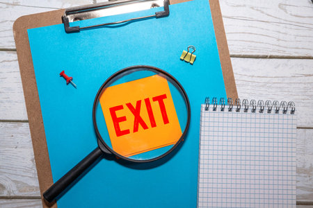 Exit sign isolated on a ceiling indoors in a building. Commonly posted safety sign in most...
