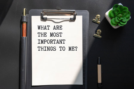 Notepad with the text WHAT ARE THE MOST IMPORTANT THINGS TO ME? on light background, with coffee