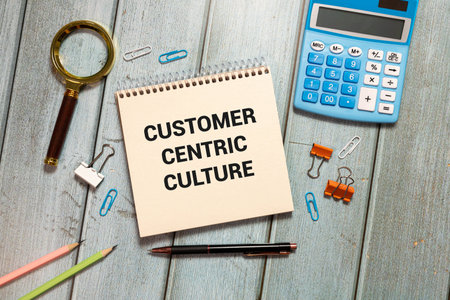 pens, felt-tip pens, notepad with text CUSTOMER-CENTRIC CULTURE on a yellow backgroundの写真素材