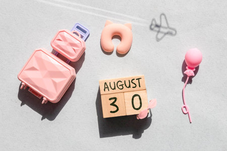 Wooden block calendar with the date August 30 on a beige concrete background