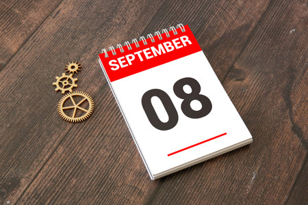 Wooden calendar with the date September 8.Monthly calendar for planning and management concept with alarm clock on wooden backgrounの写真素材