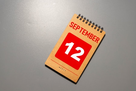 Wooden calendar with the date September 12.Monthly calendar for planning and management concept with alarm clock on wooden backgroundの写真素材