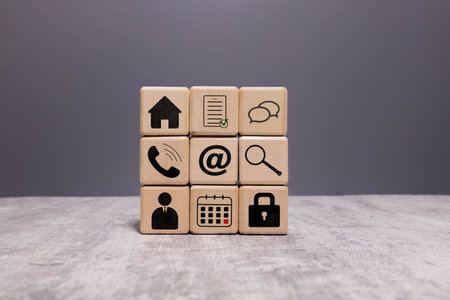 Contact us concept. Company website, FAQ, hotline phone number call, address, e-mail marketing and chat for customer support. Contact us icons on white cube blocks on blue background, vertical style.の写真素材