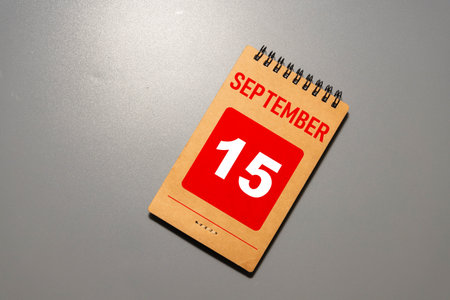 Wooden calendar with the date September 15.Monthly calendar for planning and management concept with alarm clock on wooden backgroundの写真素材