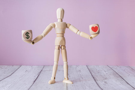 Heart and money on balance scale - Order of priority in life among love and money.