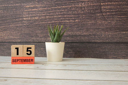 Wooden calendar with the date September 15.Monthly calendar for planning and management concept with alarm clock on wooden backgroundの写真素材