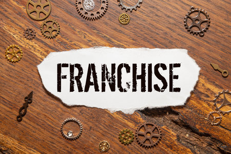 Concept of Franchise agreement written on clipboard isolated on Wooden Table.の写真素材