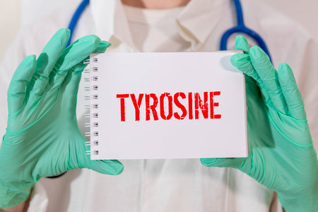 Notepad with the text and chemical structure of L Tyrosine on table with pills stethoscope. This amino acid used as a dietary supplement to improve alertness, attention and physical performances.の写真素材