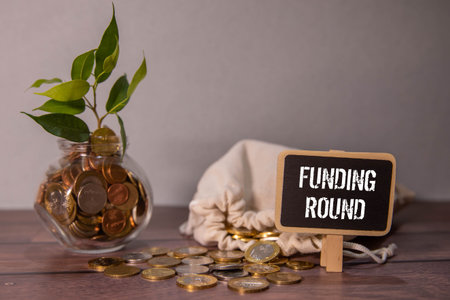 Funding round orange stickers on brown notepadの写真素材