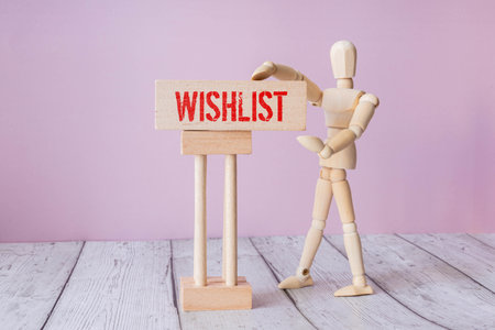 Notepad with a paper written WISHLIST on wooden office desk with flare effectの写真素材