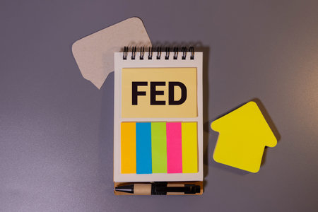 Text FED on wood cube with gold bar and newspaper on the table, economic data conceptの写真素材