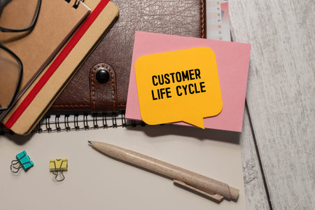On the notepad for writing the text Customer Life Cycle, magnifier,charts and glassesの写真素材