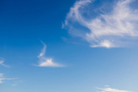 The sky is blue with a few clouds. The sun is shining brightly, making the sky look even brighter. Scene is peaceful and sereneの写真素材