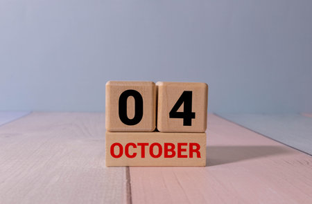 Wooden calendar with the date October 4.Monthly calendar for planning and management concept with alarm clock on wooden backgroundの写真素材